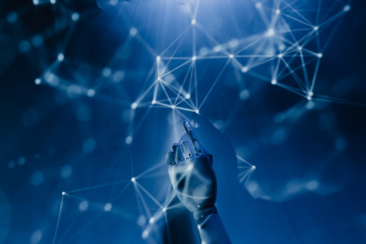 about-us-01 A robotic hand reaching into a digital network on a blue background, symbolizing AI technology.